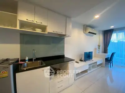 Modern open-layout kitchen and living area with sleek cabinetry and natural light.