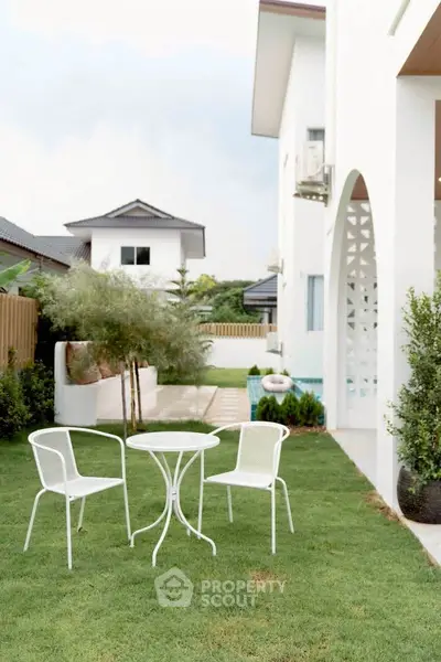 Charming garden view with elegant outdoor seating in a modern residential property.