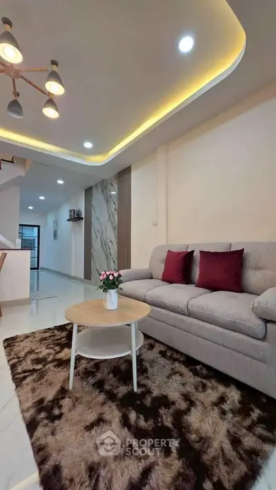 Modern living room with stylish lighting, cozy sofa, and elegant decor in a contemporary home.