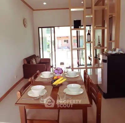 Charming dining area with elegant table setting and cozy living space, perfect for family gatherings.