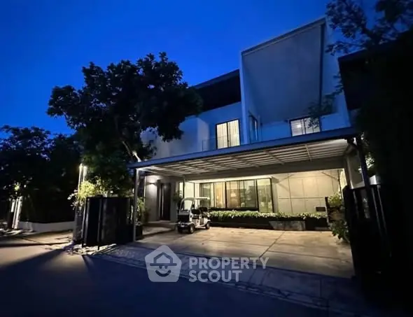 Modern house exterior with carport and night lighting