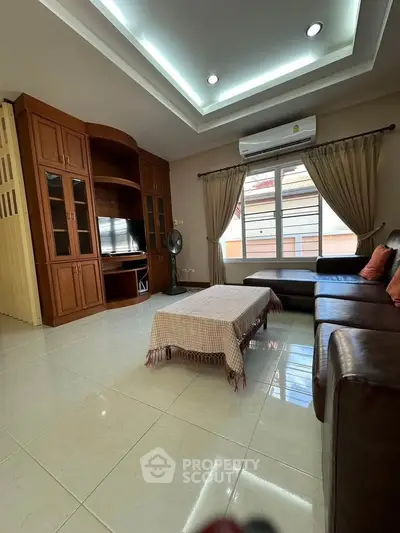 Spacious living room with elegant wooden cabinetry and cozy seating area, perfect for relaxation and entertainment.