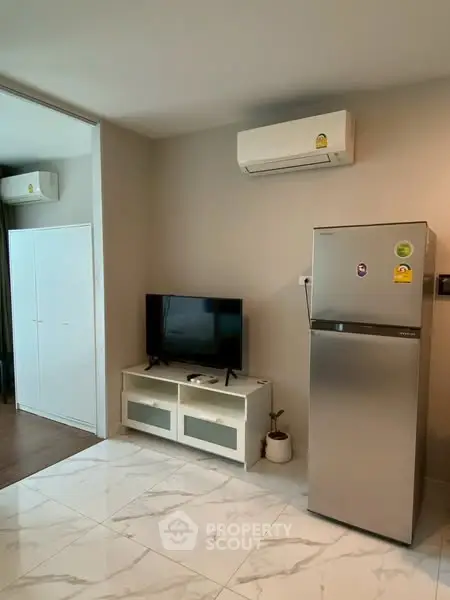 Modern living room with sleek fridge and air conditioning unit
