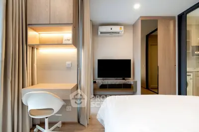 Modern bedroom with study area, featuring sleek furniture and a mounted TV, perfect for urban living.