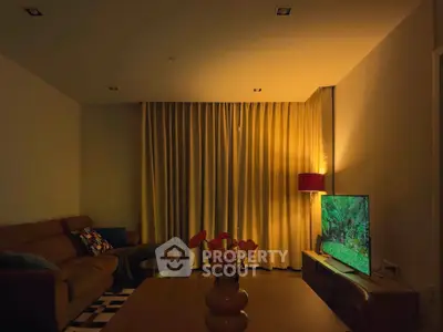 Cozy living room with modern decor and ambient lighting, featuring a comfortable sofa and a flat-screen TV.