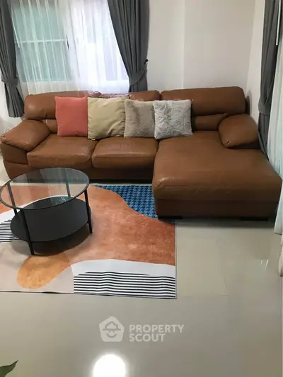 Cozy living room with stylish brown leather sectional sofa and modern glass coffee table.