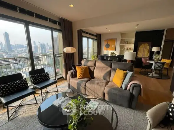 Spacious living room with city view and modern decor in high-rise apartment.