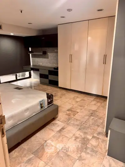 Spacious bedroom with modern built-in wardrobe and tiled flooring