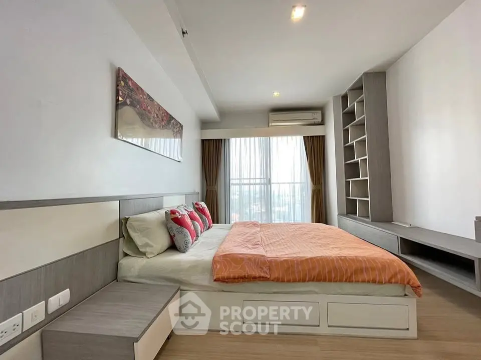 Spacious modern bedroom with stylish decor and large window view