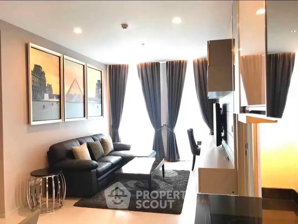 Modern living room with sleek furniture and large windows offering natural light.