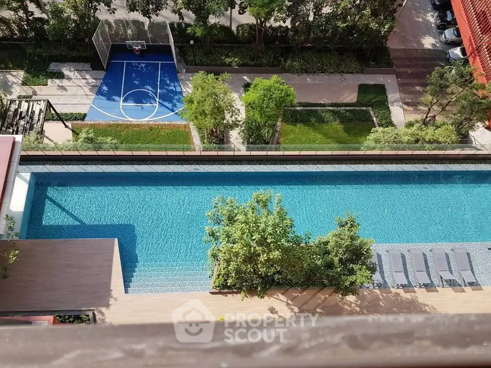 Stunning aerial view of luxury pool and basketball court in modern residential complex.