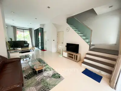 Modern living room with sleek staircase and stylish decor in a contemporary home.