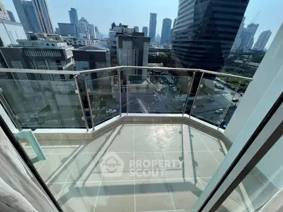 Stunning cityscape view from a modern high-rise balcony with glass railing.