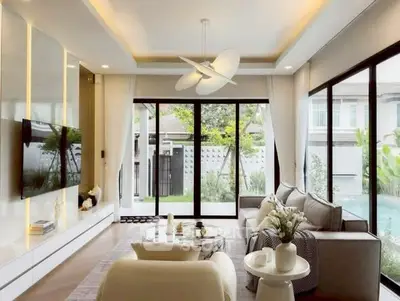 Luxurious living room with modern decor and pool view, featuring elegant furniture and large windows.