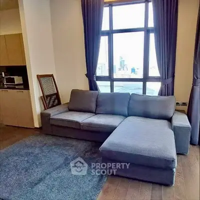 Modern living room with large window and cozy gray sectional sofa.