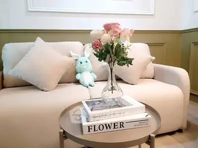 Charming living room with plush sofa, decorative pillows, and elegant floral centerpiece on a stylish coffee table.
