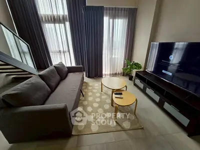 Modern living room with stylish sofa, large TV, and elegant decor