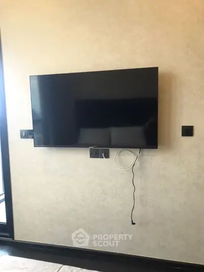 Modern living room with wall-mounted flat-screen TV and sleek design.