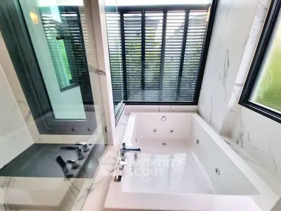 Luxurious bathroom with a modern bathtub and large windows for natural light.