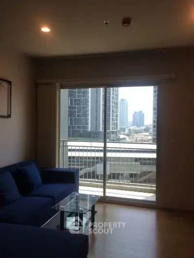 Modern living room with city view from large window and stylish blue sofa.