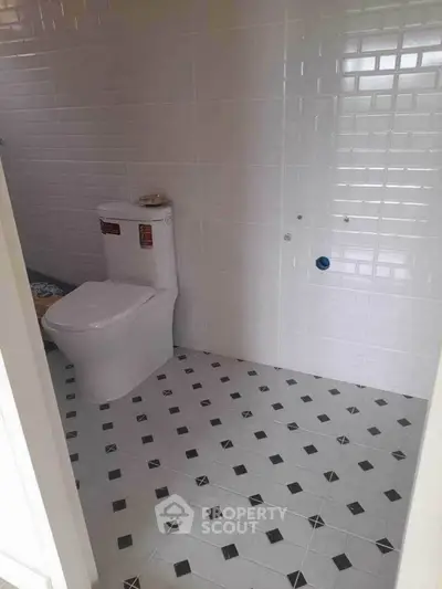 Modern bathroom with white tiled walls and geometric floor pattern