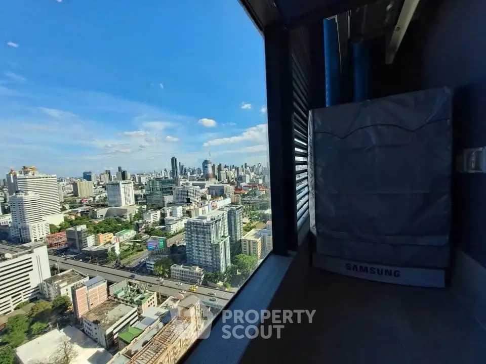 Stunning cityscape view from high-rise balcony with modern appliances.
