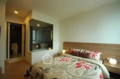 Modern bedroom with floral bedding and glass partition to bathroom