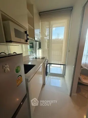 Modern kitchen with sleek appliances and natural light in a compact layout.