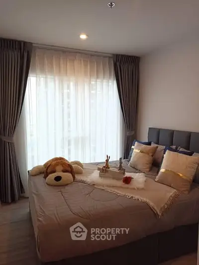 Cozy bedroom with plush bedding and elegant curtains, perfect for relaxation.