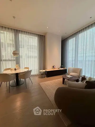 Elegant living room with modern furniture and large windows offering natural light.