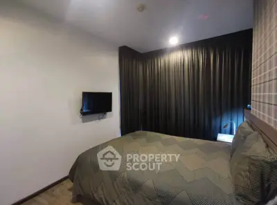 Cozy bedroom with modern decor and wall-mounted TV, perfect for relaxation.