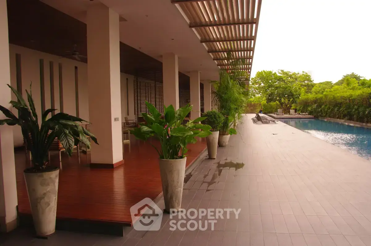 Luxurious poolside area with modern design and lush greenery, perfect for relaxation and leisure.
