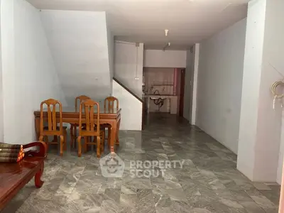 Spacious open-plan living area with dining set and tiled flooring