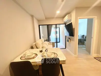 Modern living room with dining area and balcony access in a stylish apartment.