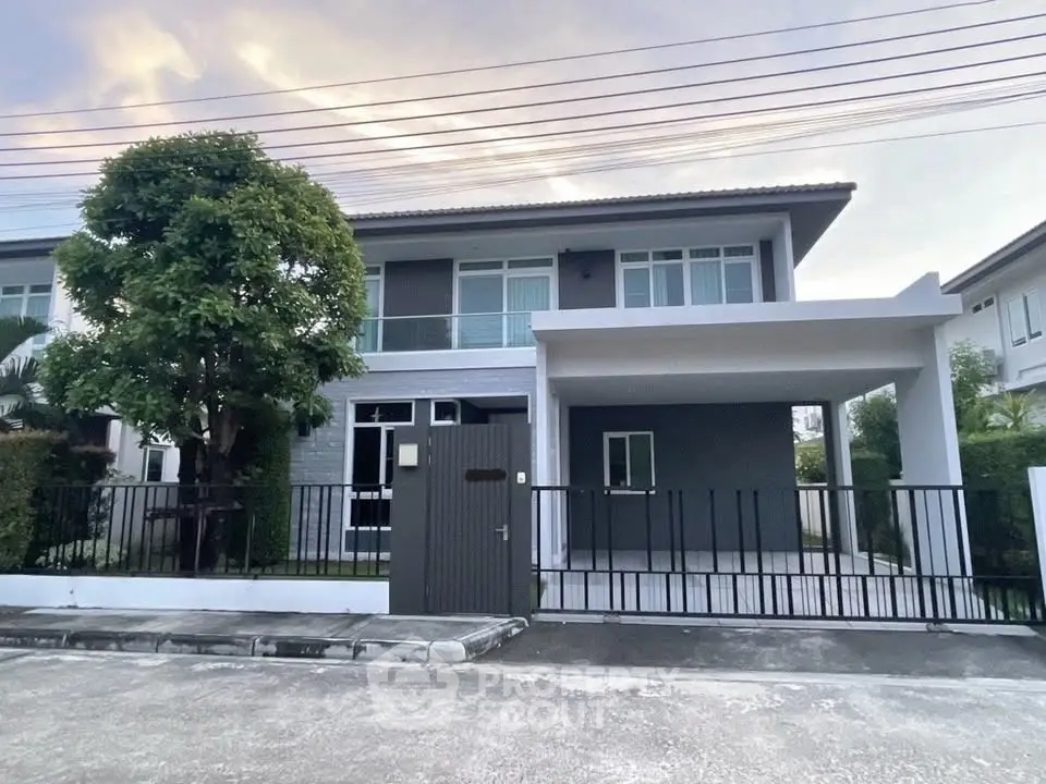 Modern two-story house with sleek design and spacious driveway in a serene neighborhood.