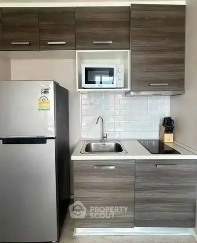 Modern compact kitchen with sleek cabinetry and stainless steel appliances