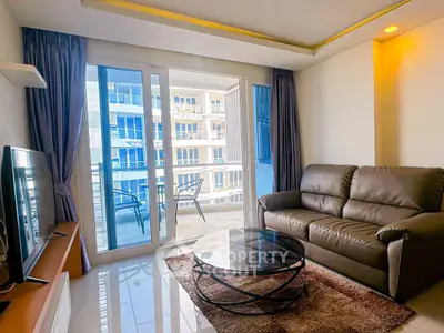 Modern living room with balcony view, leather sofa, and sleek glass coffee table.