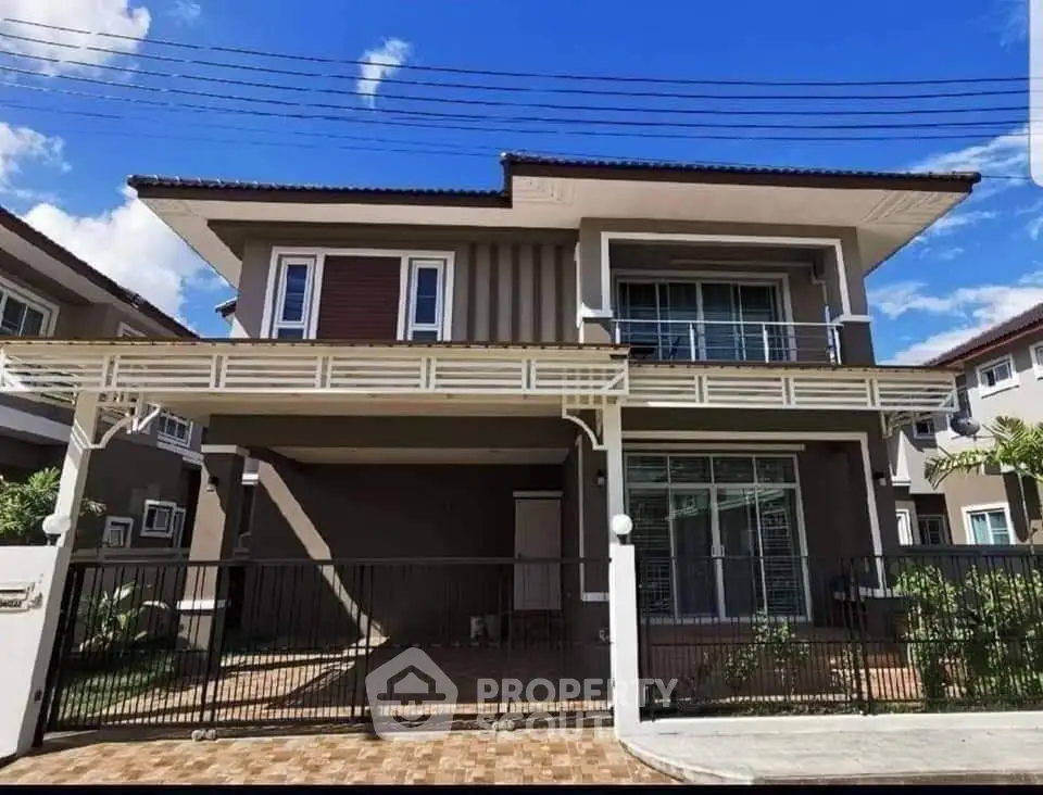 Stunning two-story modern house with spacious balcony and elegant facade under clear blue sky.