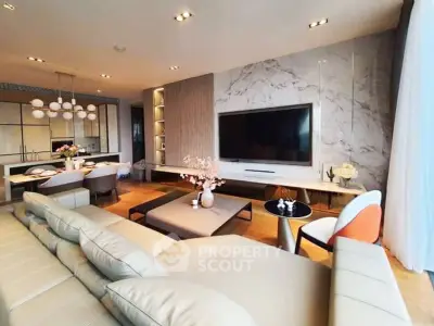 Luxurious modern living room with elegant decor and open layout, featuring a large TV and stylish furniture.