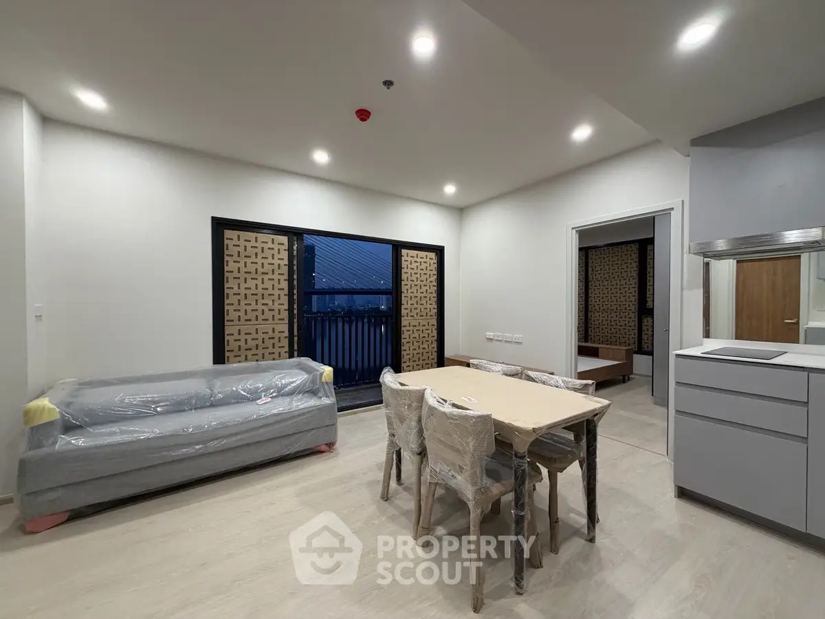 Modern living room with dining area and balcony access in a stylish apartment.