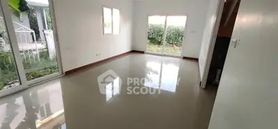 Spacious living room with large windows and garden view, perfect for natural light lovers.