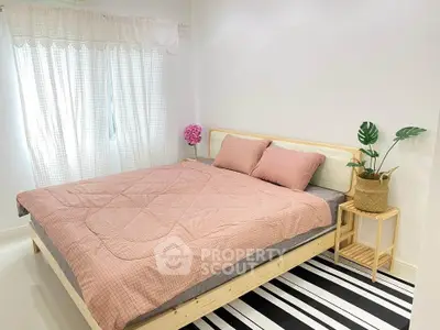 Cozy bedroom with stylish decor and natural light, featuring a comfortable bed and modern furnishings.