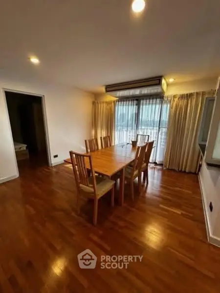 Spacious dining area with wooden flooring and elegant table set