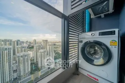 High-rise apartment with city view and modern washing machine on balcony.