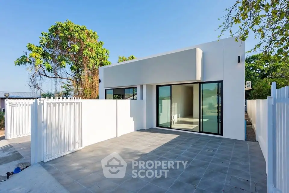 Modern minimalist home exterior with sleek design and spacious patio area.