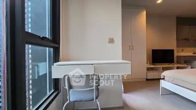 Modern bedroom with study area and large window in urban apartment