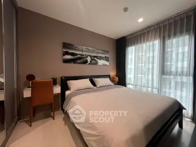 Modern bedroom with large bed, stylish decor, and ample natural light from floor-to-ceiling windows.