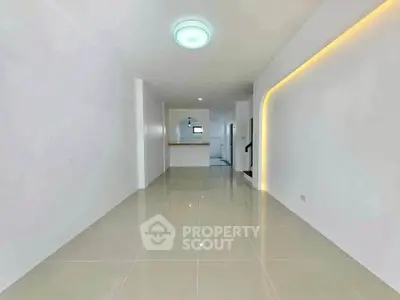 Spacious open-plan living area with modern lighting and sleek tile flooring