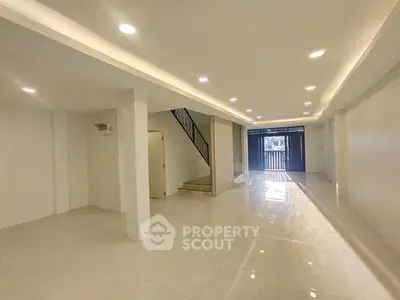 Spacious open-plan living area with modern lighting and staircase, perfect for family gatherings.