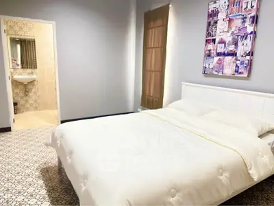 Spacious bedroom with elegant decor and ensuite bathroom, perfect for modern living.